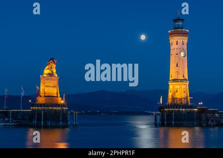 Nachtansicht auf den Leuchtturm und die Skulptur des bayerischen Löwen im Hafen von Lindau, Bayern Stockfoto