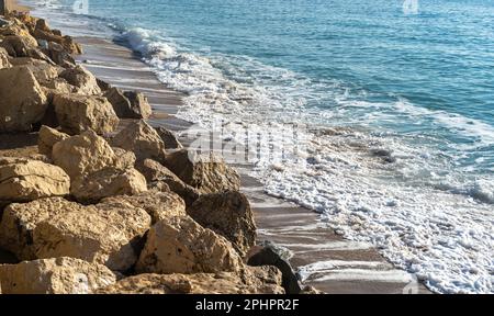 Schäumende Wellen, Sturm auf Rocky Beach Texture Hintergrund, Blauer Ozean Wasser, Rocky Shore Muster, Stone Shoreline, Urlaubskonzept Stockfoto