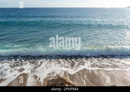 Meereswellen am Sandstrand Hintergrund, transparentes Ozeanwasser, Blauer Himmel, Golden Sunny Shore Muster, Summer Mockup mit Copy Space Stockfoto