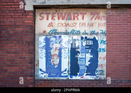 Fliegenposter an der Backsteinwand des Lagerhauses Stockfoto