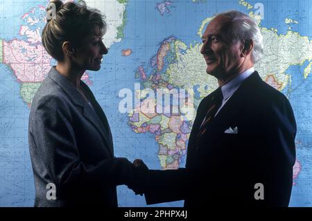 1990 HISTORISCHE SILHOUETTE VON BÜROANGESTELLTEN AUF DER WELTKARTE („RAND MCNALLY 1990“) Stockfoto