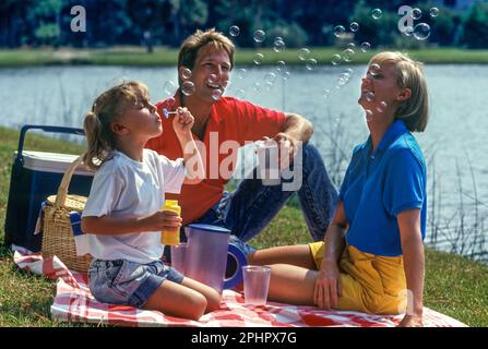 FAMILIENSPASS IM FREIEN AUF EINEM PICKNICK AM SEE Stockfoto