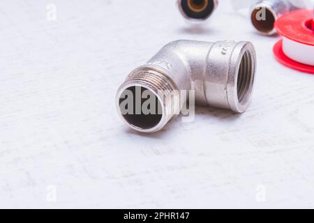 Ein Wasserhahn und ein Schlauch in einem Metallgeflecht. Zubehör zur Reparatur der Wasserversorgung. Stockfoto