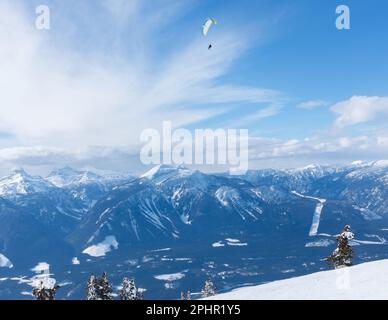 Schnellfliegen oder Parasailing mit Skifahren ist eine großartige Möglichkeit, das Columbia River Valley in der Nähe von Revelstoke, British Columbia, Kanada, zu sehen. Stockfoto