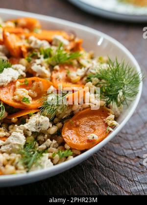 Hausgemachten gerösteten Karotten- und Gerstensalat mit veganem Feta. Stockfoto