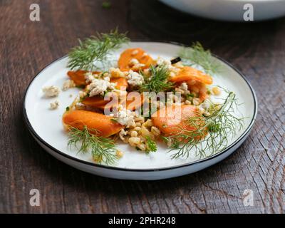 Hausgemachten gerösteten Karotten- und Gerstensalat mit veganem Feta. Stockfoto