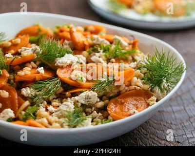 Hausgemachten gerösteten Karotten- und Gerstensalat mit veganem Feta. Stockfoto