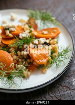 Hausgemachten gerösteten Karotten- und Gerstensalat mit veganem Feta. Stockfoto