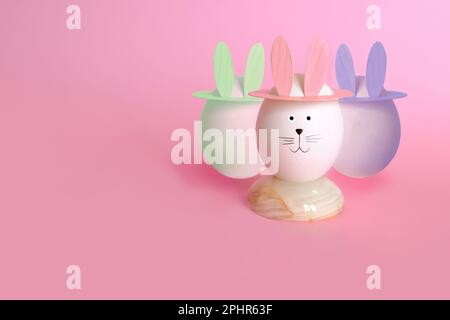 ostereier mit Kaninchenohren auf rosa Hintergrund Stockfoto