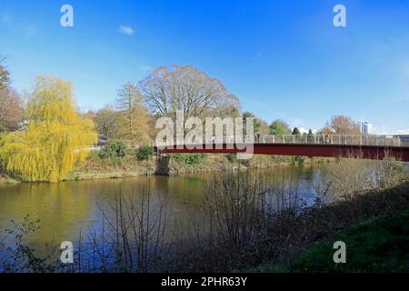 Millennium Bridge, über den Fluss Taff von Sophia Gardens zu Castle Grounds / Bute Park, Cardiff mit weinender Weide und blauem Himmel. März 2023 Stockfoto