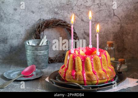 Orangefarbener Vanillekuchen mit pinkfarbenem Glasur, Osterdekor. Stockfoto