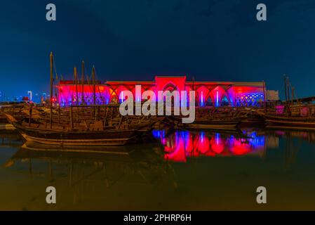 Traditionelle Dhows, die nachts in Doha in Katar vor Anker gehen. Stockfoto