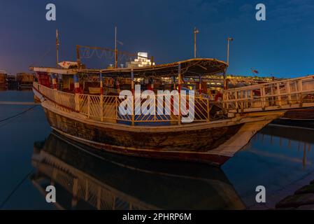 Traditionelle Dhows, die nachts in Doha in Katar vor Anker gehen. Stockfoto