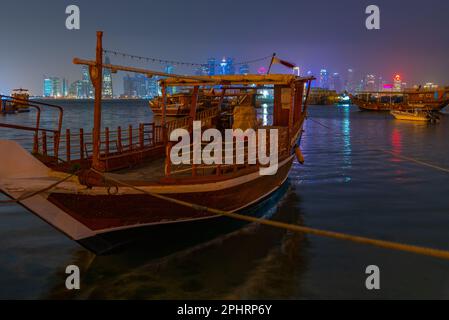 Traditionelle Dhows, die nachts in Doha in Katar vor Anker gehen. Stockfoto