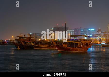 Traditionelle Dhows, die nachts in Doha in Katar vor Anker gehen. Stockfoto