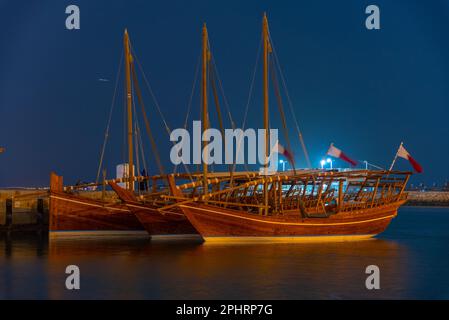 Traditionelle Dhows, die nachts in Doha in Katar vor Anker gehen. Stockfoto