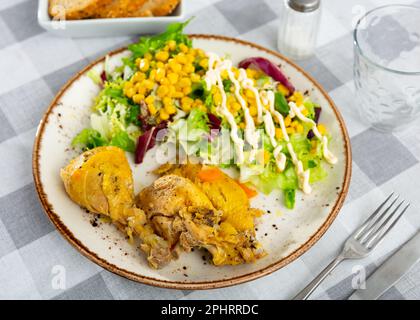 Gebackene Hähnchenteile mit Salat und Mais Stockfoto