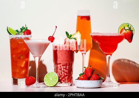 Sommercocktails mit Erdbeeren, Mocktails, Smoothies und Shakes mit Früchten und Beeren in Gläsern. Erfrischende kalte Getränke. Beige rosa Vanille Stockfoto