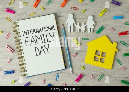 Alles Gute Zum Familientag. Flache Liegezusammensetzung mit Notizbuch, Figuren und Schreibwaren auf Holztisch Stockfoto