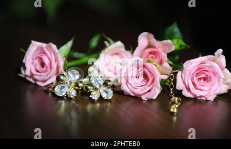 Blassrosa Rosen liegen auf einem dunklen Spiegelhintergrund für Werbung, es gibt Platz für Text. Hochwertiges Foto Stockfoto