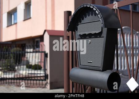 Schöner Briefkasten mit Zeitungshalter auf Metallzaun im Freien, Platz für Text Stockfoto