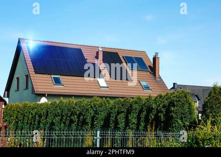 Haus mit installierten Sonnenkollektoren auf dem Dach. Alternative Energie Stockfoto