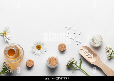 Homöopathische Arzneimittel und Heilpflanzen auf hellem Hintergrund, Kopierraum. Stockfoto