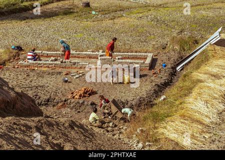 Bhaktapur, Nepal. 9. November 2021. Eine Familie mit Kindern sah, wie sie eine Hütte vor dem Backsteinofen baute. In den letzten Jahren ist die Zahl der Kinder, die in den Ziegelöfen Nepals arbeiten, stark gestiegen. Nach dem Erdbeben von 2015 und der Covid-19-Pandemie waren viele Kinder gezwungen, ihren Familien beim Überleben zu helfen. Viele von ihnen haben einen einfachen Ausweg in der Ziegelindustrie gefunden, einem "informellen Sektor", in dem die Einstellung von Arbeitnehmern ungeregelt ist und es nur wenige Kontrollen gibt. (Kreditbild: © Simone Boccaccio/SOPA Images via ZUMA Press Wire) NUR REDAKTIONELLE VERWENDUNG! Nicht für den kommerziellen GEBRAUCH! Stockfoto