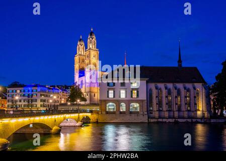 Blick auf den Sonnenuntergang über den Fluss Limmat mit dem Großmünster und der Wasserkirche in Zürich, Schweiz. Stockfoto