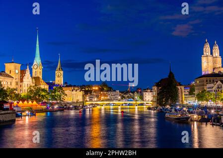 Blick auf das historische Stadtzentrum von Zürich bei Sonnenuntergang mit den berühmten Fraumünster- und Großmünsterkirchen und dem Fluss Limmat, Schweiz. Stockfoto