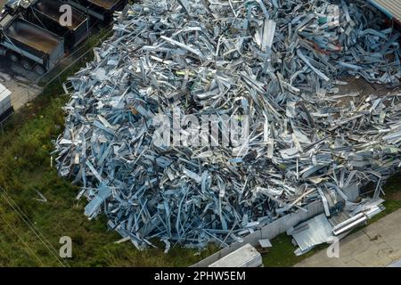 Luftaufnahme eines großen Haufens Aluminiumschrott aus kaputten Häusern, nachdem der Hurrikan Ian durch Florida gefegt hatte. Recyceln defekter Teile von mobilen Geräten Stockfoto