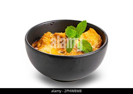 Blick aus einem hohen Winkel auf würziges, köstliches hausgemachtes Hühnercurry mit Kartoffeln und Kokosmilch in schwarzer Keramikschüssel isoliert auf weißem Hintergrund mit Clippin Stockfoto