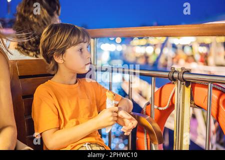 Tourismusjunge, der türkisches Eis mit der Fähre auf dem Bosporus isst. Das Konzept „Reisen mit Kindern“ Stockfoto