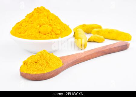 Kurkumapulver in Schüssel und Löffel isoliert auf weißem Hintergrund Stockfoto