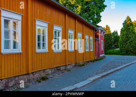 Blick auf den Sonnenuntergang über Holzgebäude im Vanha Rauma-Bezirk in Rauma in Finnland. Stockfoto