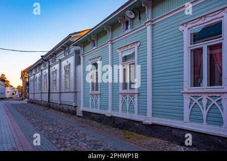 Blick auf den Sonnenuntergang über Holzgebäude im Vanha Rauma-Bezirk in Rauma in Finnland. Stockfoto