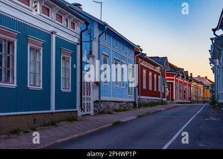 Blick auf den Sonnenuntergang über Holzgebäude im Vanha Rauma-Bezirk in Rauma in Finnland. Stockfoto