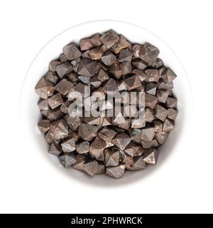 Magnetitkristalle in einer weißen Schüssel. Eisen(II,III)-oxid, achtahedral, Doppelpyramide und platonisch massiv. Die magnetischsten aller vorkommenden Mineralien. Stockfoto