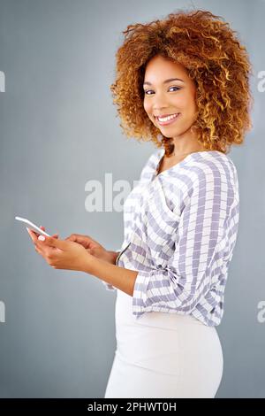Voller Selbstvertrauen. Studioaufnahme einer jungen Geschäftsfrau vor grauem Hintergrund. Stockfoto