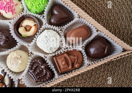 Verschiedene handgemachte Süßigkeiten, Schweizer Pralinen in Geschenkbox, verschiedene luxuriöse Pralinen aus dunkler und milchhaltiger Bio-Schokolade, süßes Dessertessen als Urlaub Stockfoto