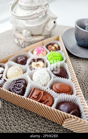 Verschiedene handgemachte Süßigkeiten, Schweizer Pralinen in Geschenkbox, verschiedene luxuriöse Pralinen aus dunkler und milchhaltiger Bio-Schokolade, süßes Dessertessen als Urlaub Stockfoto
