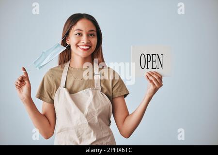 Café-Bar, Covid und eine Frau mit offenem Schild im Studio auf grauem Hintergrund nach dem Abriegeln. Hochformat, kleine Unternehmensgründungen und Café mit einem Stockfoto