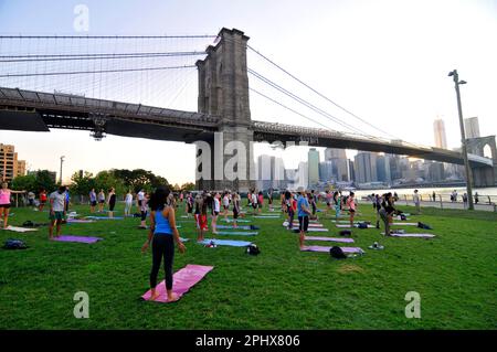 Yoga-Session bei Sonnenuntergang im Brooklyn Bridge Park in New York City, NY, USA. Stockfoto