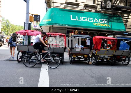 Dreirädrige Rikschas parken an der Ecke West 58. Street und 6. Ave. In Manhattan, New York City, USA. Stockfoto