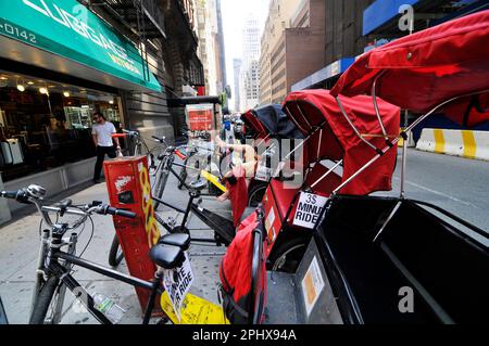 Dreirädrige Rikschas parken an der Ecke West 58. Street und 6. Ave. In Manhattan, New York City, USA. Stockfoto