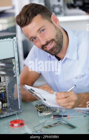 Mann, der Notizen über einen pc schreibt Stockfoto