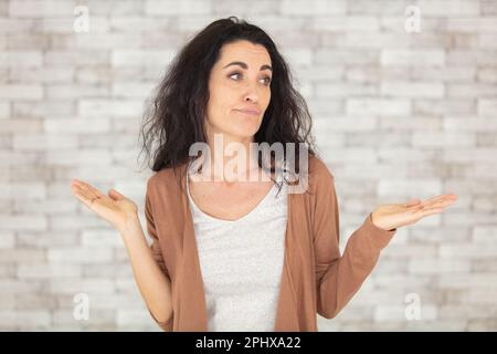 Glückliche Seniorin, die auf Tapetenhintergrund gestrickt hat Stockfoto