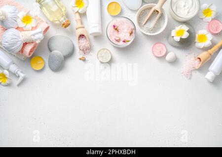 Beauty- und Spa-Konzept auf weißem Betonhintergrund. Blauer Lehm mit Creme und Massagesteinen. Stockfoto