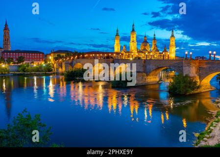 Nachtsicht auf die Basilika de nuestra senora de pilar, catedral del salvador de zaragoza und puente de piedra in Saragoza, Spanien. Stockfoto