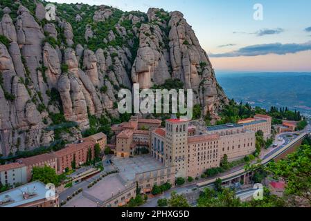Panoramablick bei Sonnenuntergang auf die Abtei Santa Maria de Montserrat in Spanien. Stockfoto